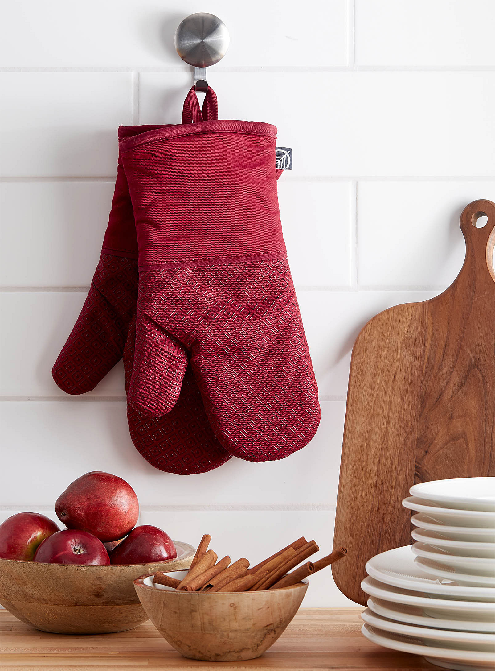 A pair of oven mitts hanging from the wall