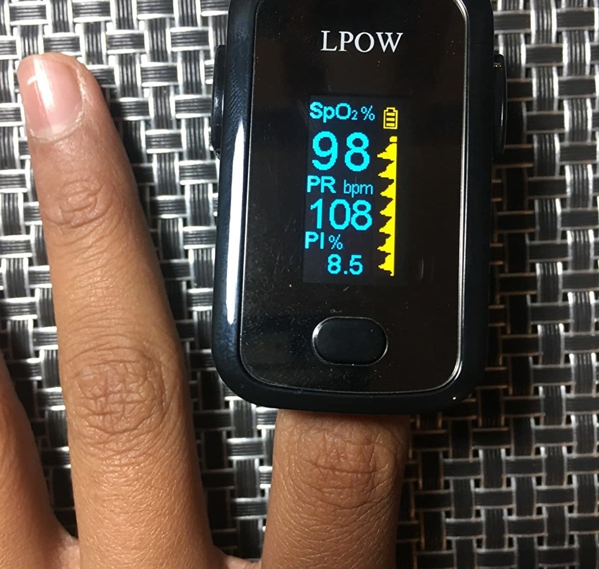 reviewer showing the pulse oximeter on their index finger 