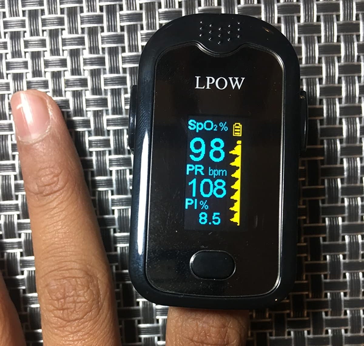 reviewer showing the pulse oximeter on their index finger 