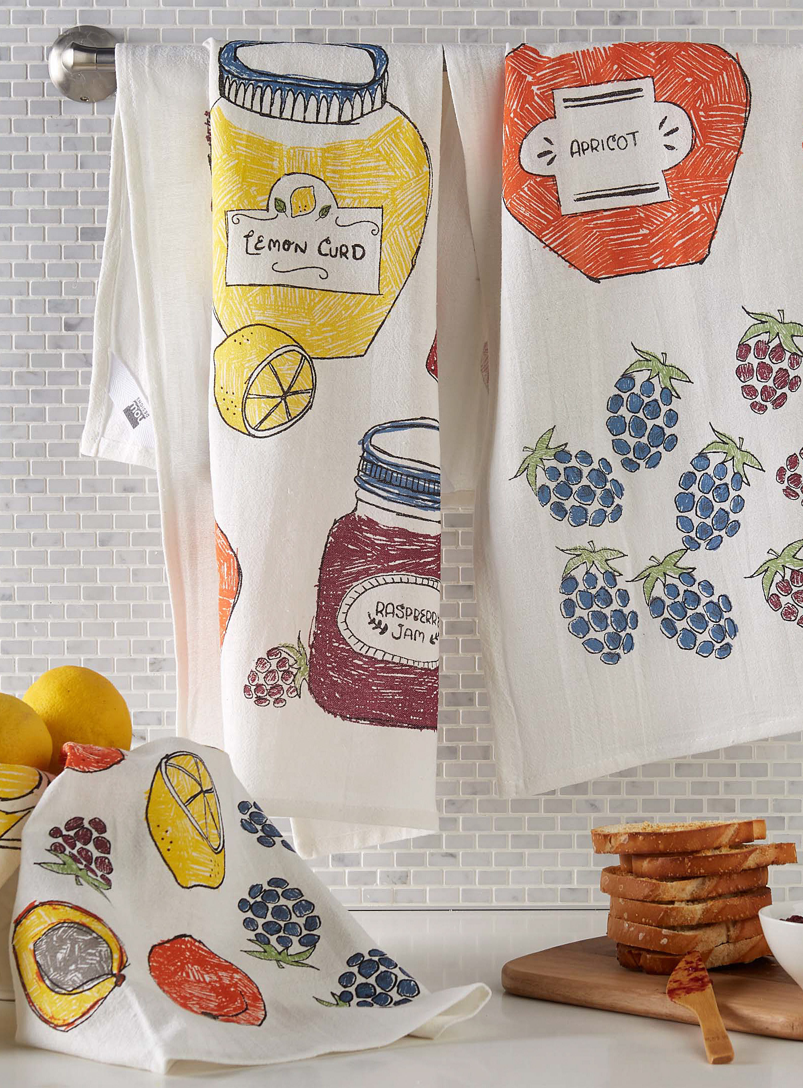 Two tea towels hanging on a bar above a kitchen counter