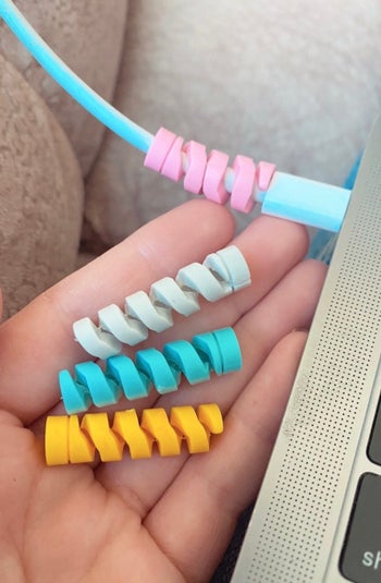 four spiral shaped charger protectors, one of which is on a mac charger at the charger point