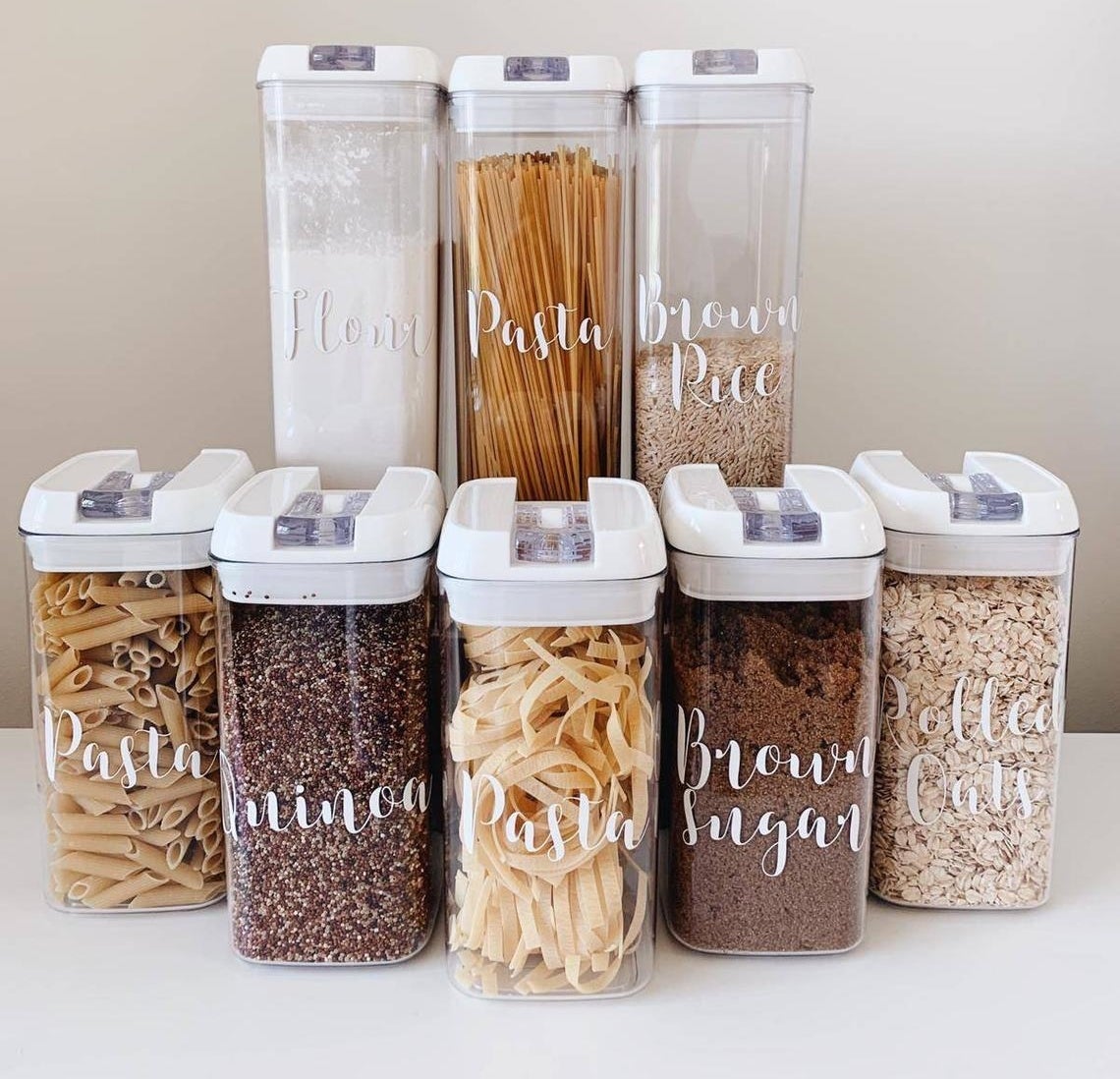 Five food storage containers with labels on the front