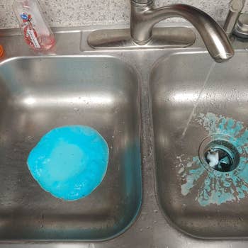 A customer review photo showing the disposal cleaner bubbling up through the drains of their sink 