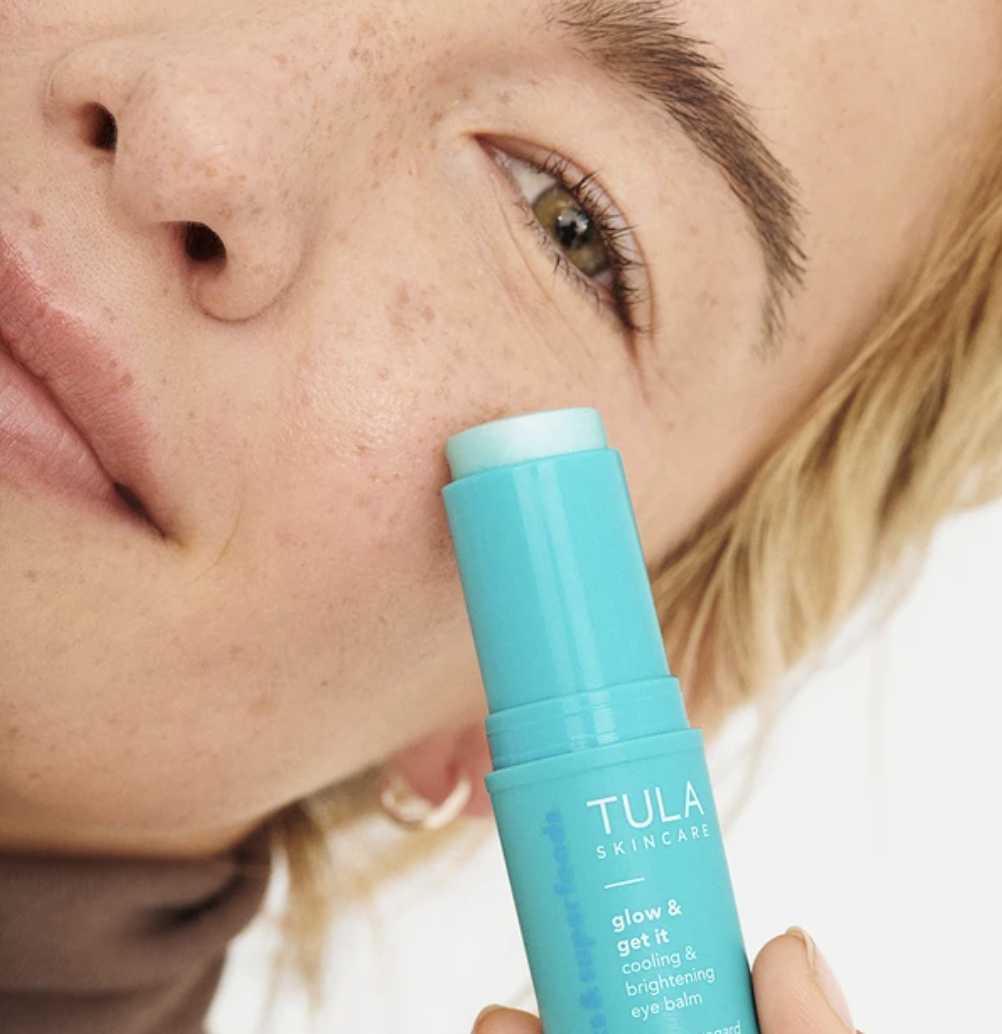 Model applying Tula Skincare eye balm