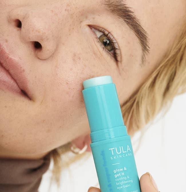 Image of model applying Tula Skincare eye balm