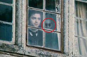 Daniel Radcliff staring out the window with a ghost behind him