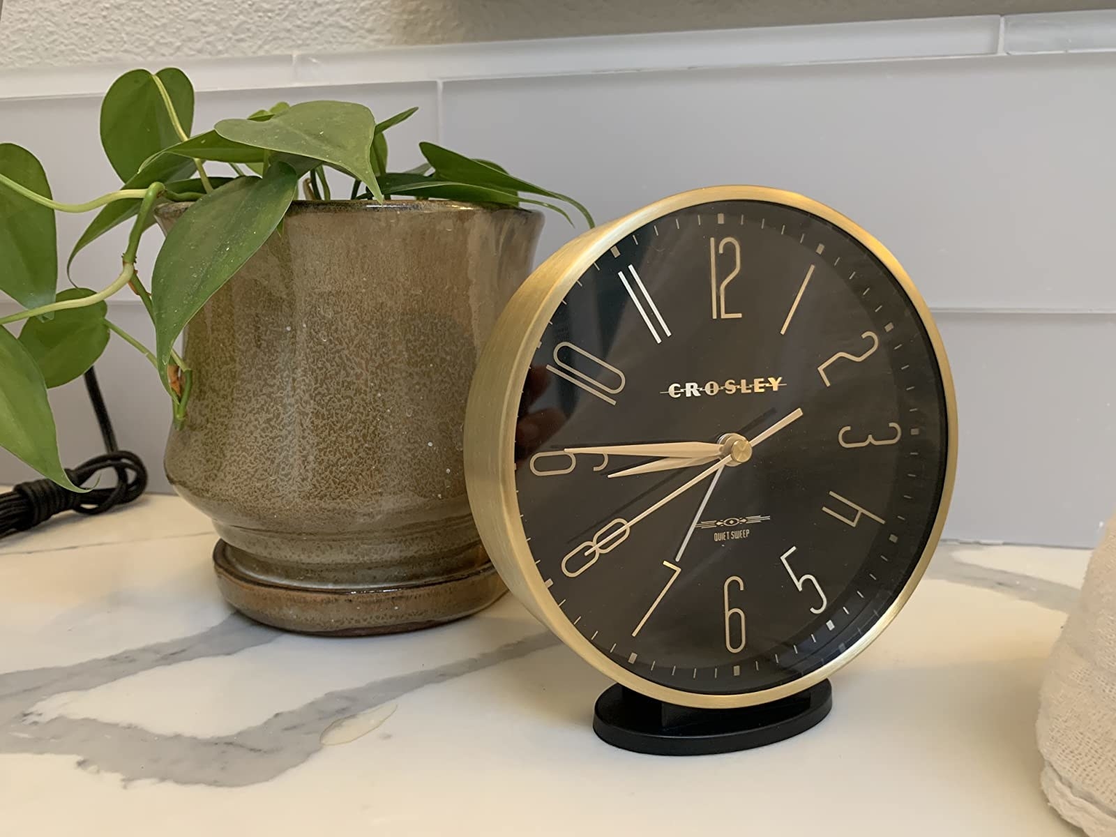 reviewer image of the small round black clock with gold outside and number and hands