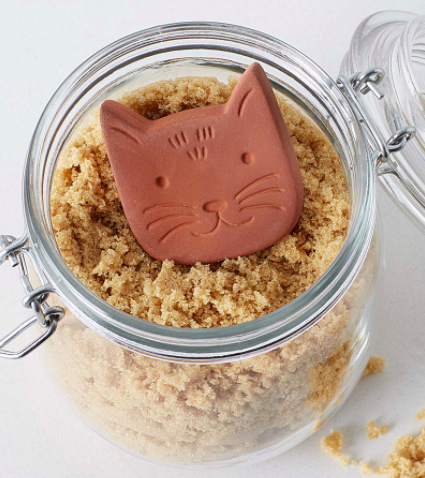 A terracotta cat inside a jar of brown sugar