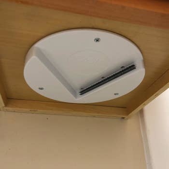 A reviewer photo of the lid opener mounted under the cabinet 