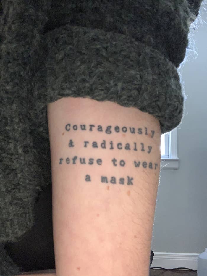 A close-up of Holland&#x27;s tattoo reading &quot;courageously &amp; radically refuse to wear a mask&quot;