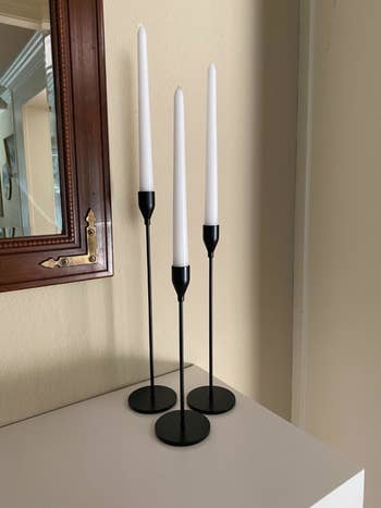 a reviewer's candle sticks on a mantle in black