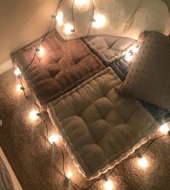 The cushions with string lights surrounding them