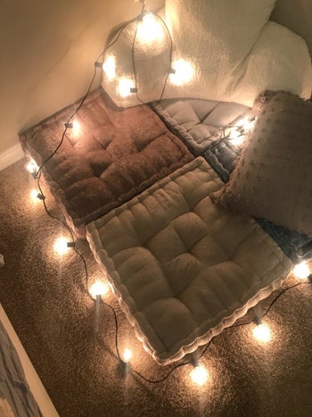 The cushions with string lights surrounding them