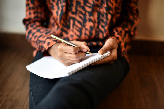 Someone sits and journals in a notebook, like they're making a new plan