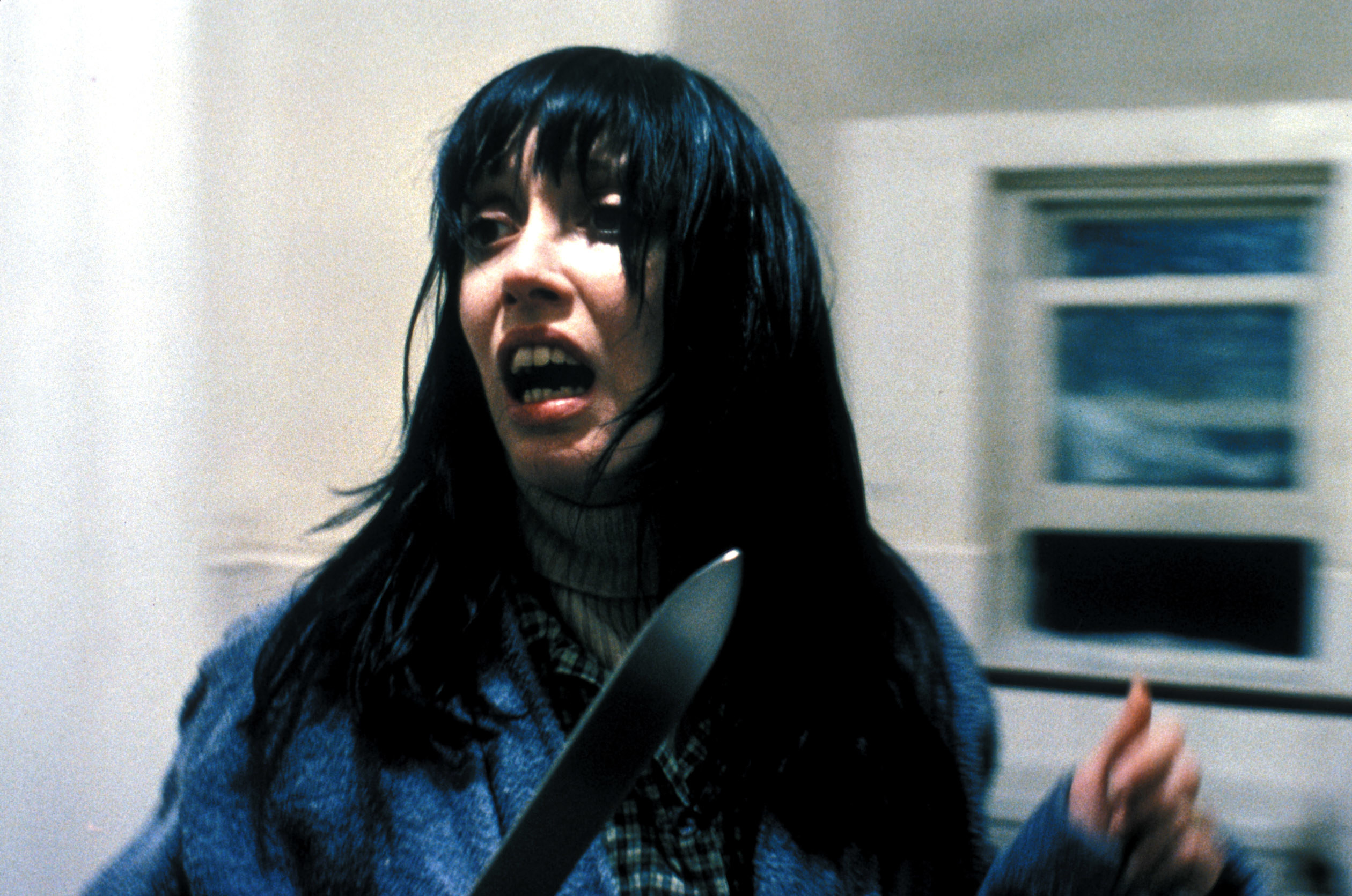 Shelly with a knife looking scared in the film
