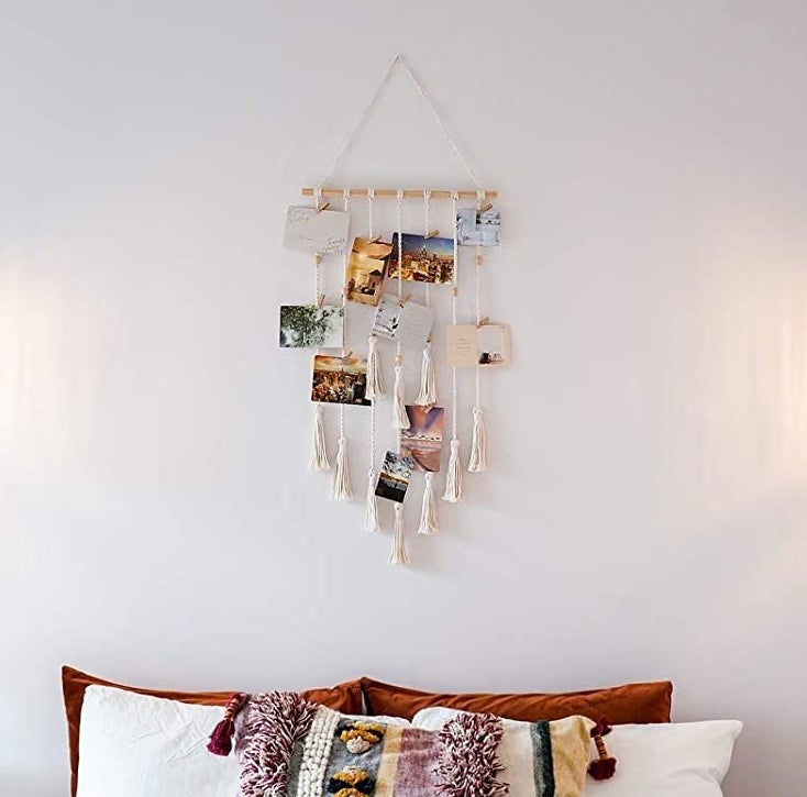 a macrame photo organizer hanging above a bed
