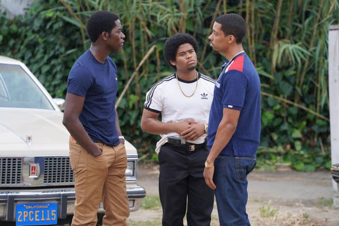 Damson Idris, Isaiah John, Melvin Gregg standing and talking to one another outside in a scene from SnowFall