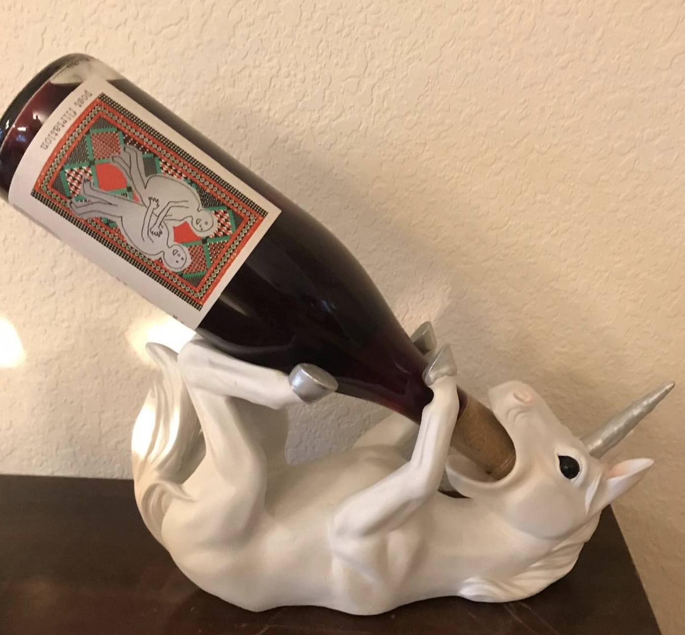 the unicorn bottle holder holding a bottle of wine
