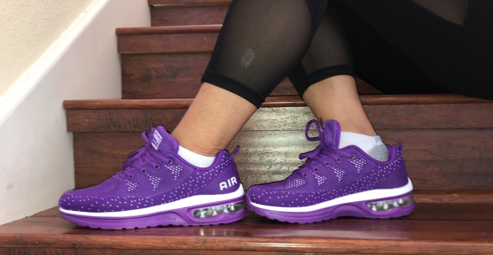reviewer wears purple and white breathable sneakers with cushioning section on bottom
