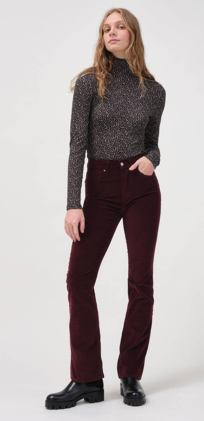 model wearing burgundy corduroy pants with doc martens and a turtleneck