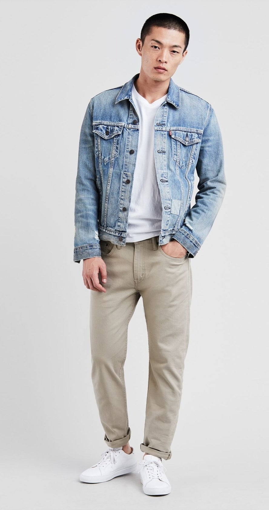 model wearing khaki taper fit jeans that are rolled on the ends