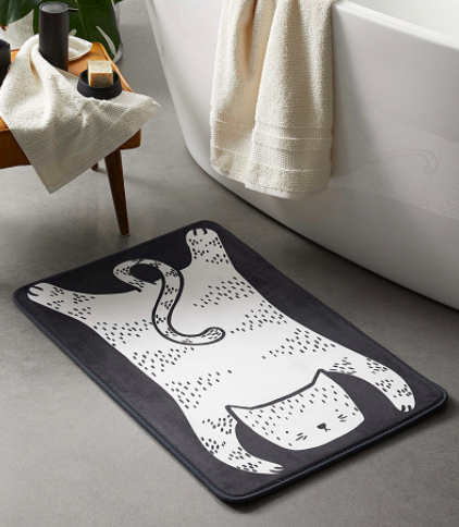 A padded bath mat with a graphic cat design on it