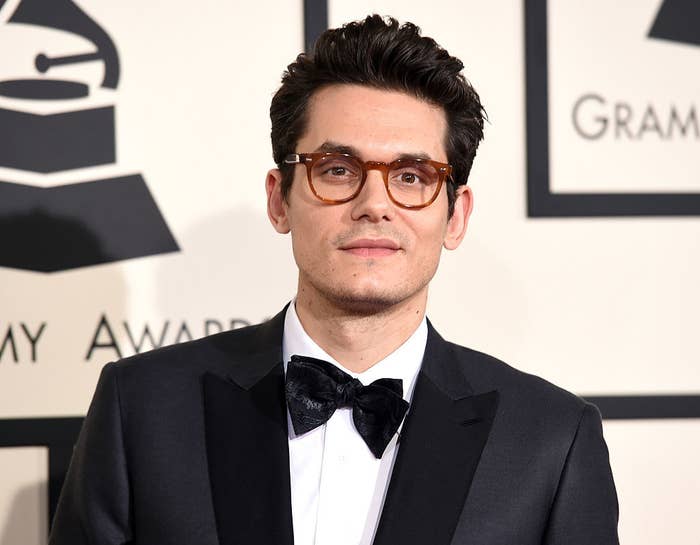 John Mayer wearing a suit, bowtie, and eyeglasses on the Grammy Awards red carpet