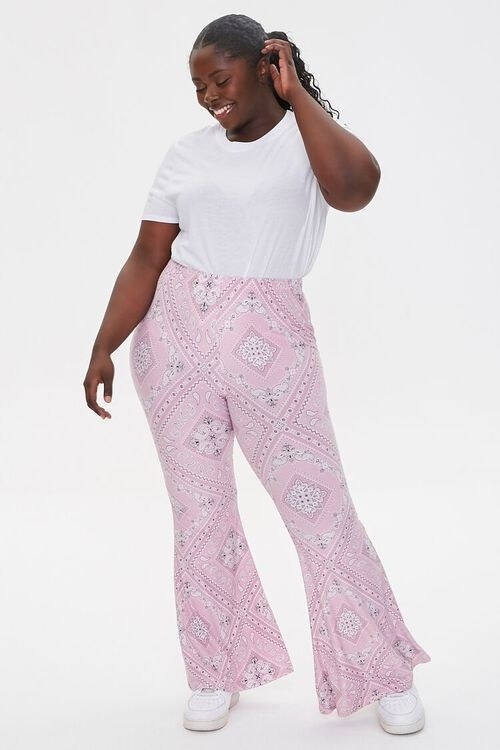 Model wearing the pink flare-legged pants and a white t-shirt