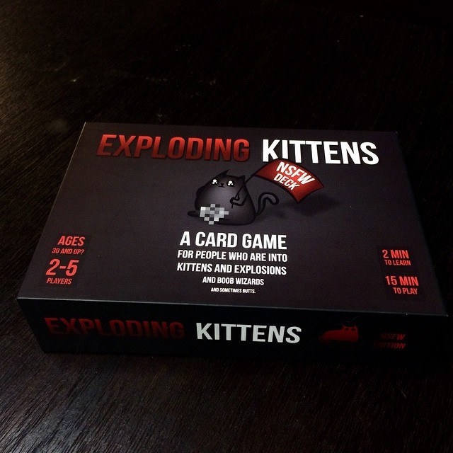 A box of the NSFW edition of Exploding Kittens on a dark background