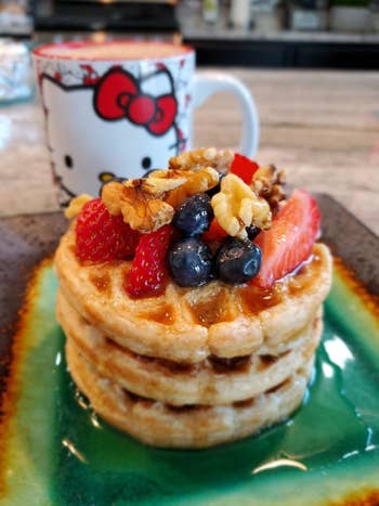 a stack of three waffles made with the griddle with syrup and fruit on top