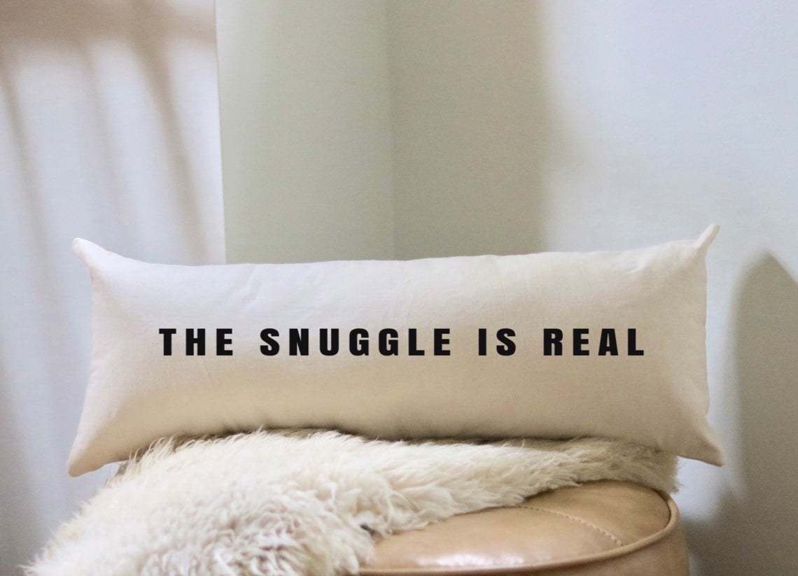 &quot;The snuggle is real&quot; writing on a lumbar pillow 