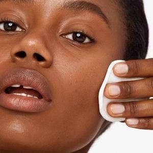 model uses cotton pad to rub same hydrating milk onto cheeks