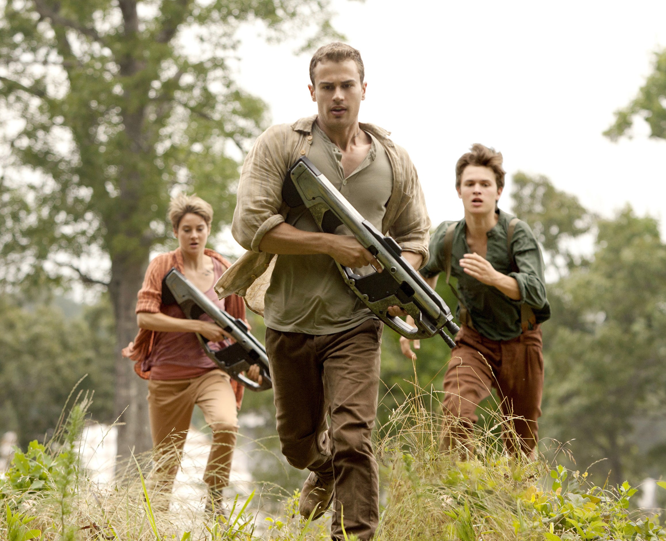 Shailene Woodley, Theo James, and Ansel Elgort running in an action scene in &quot;The Divergent Series: Insurgent&quot;