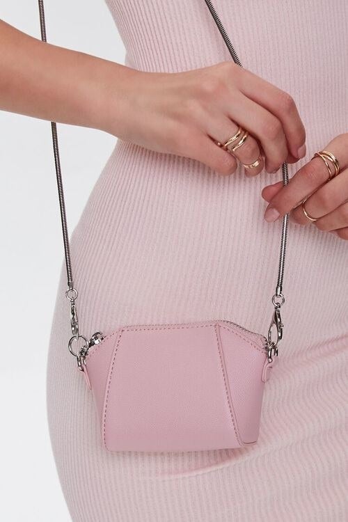 A pink mini cross body bag with a long strap 