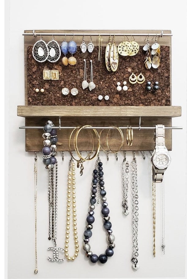 jewelry organizer hung up styled with tons of different jewelry pieces