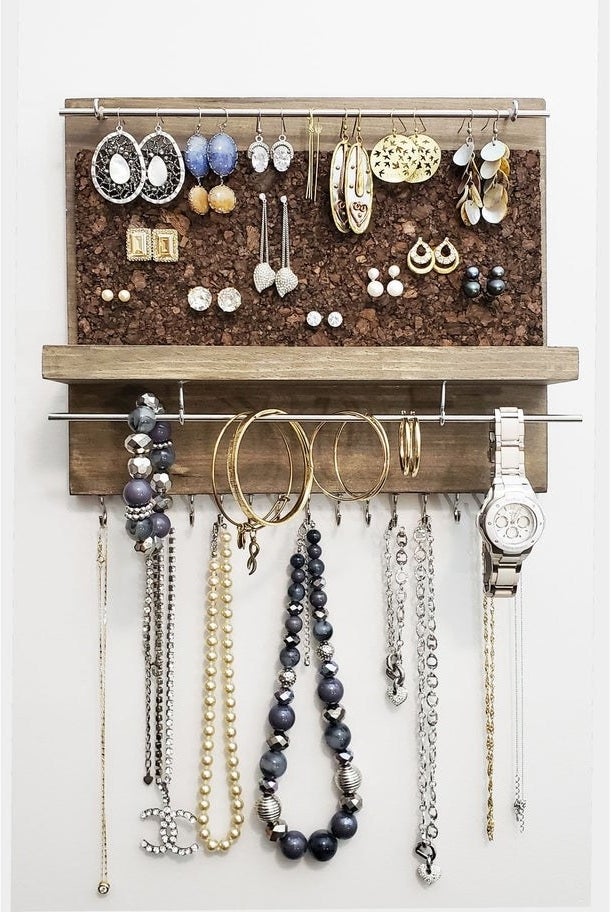 jewelry organizer hung up styled with tons of different jewelry pieces