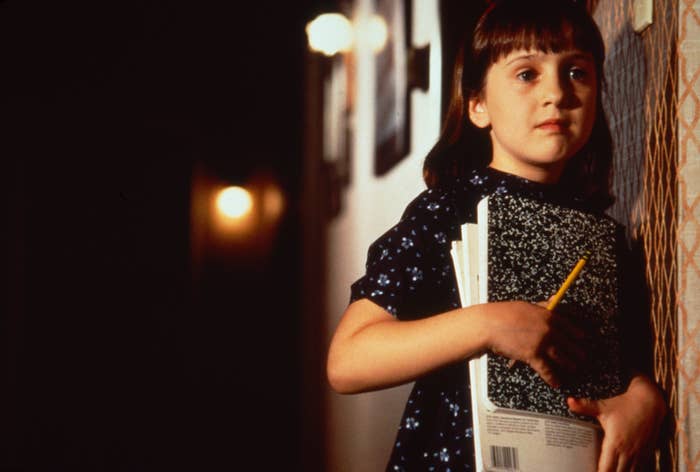 Mara Wilson holding a notebook and pencil in Matilda