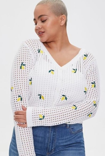 Model wearing the white open knit cropped sweater with lemon embroidery 