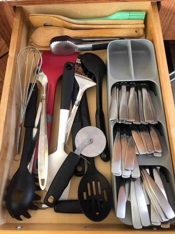 reviewer photo showing the silverware organizer along with several other kitchen utensils in the drawer 