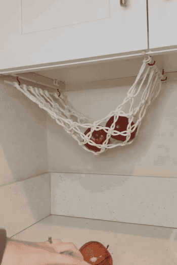 gif of model putting apples and oranges in the hanging basket 