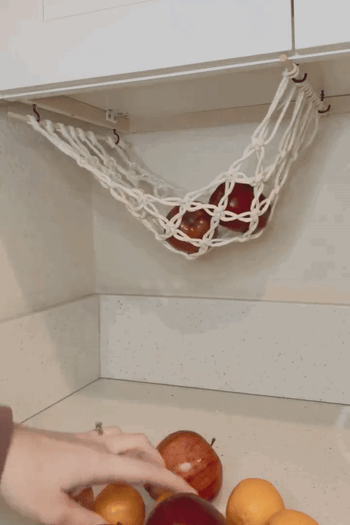 gif of model putting apples and oranges in the hanging basket 