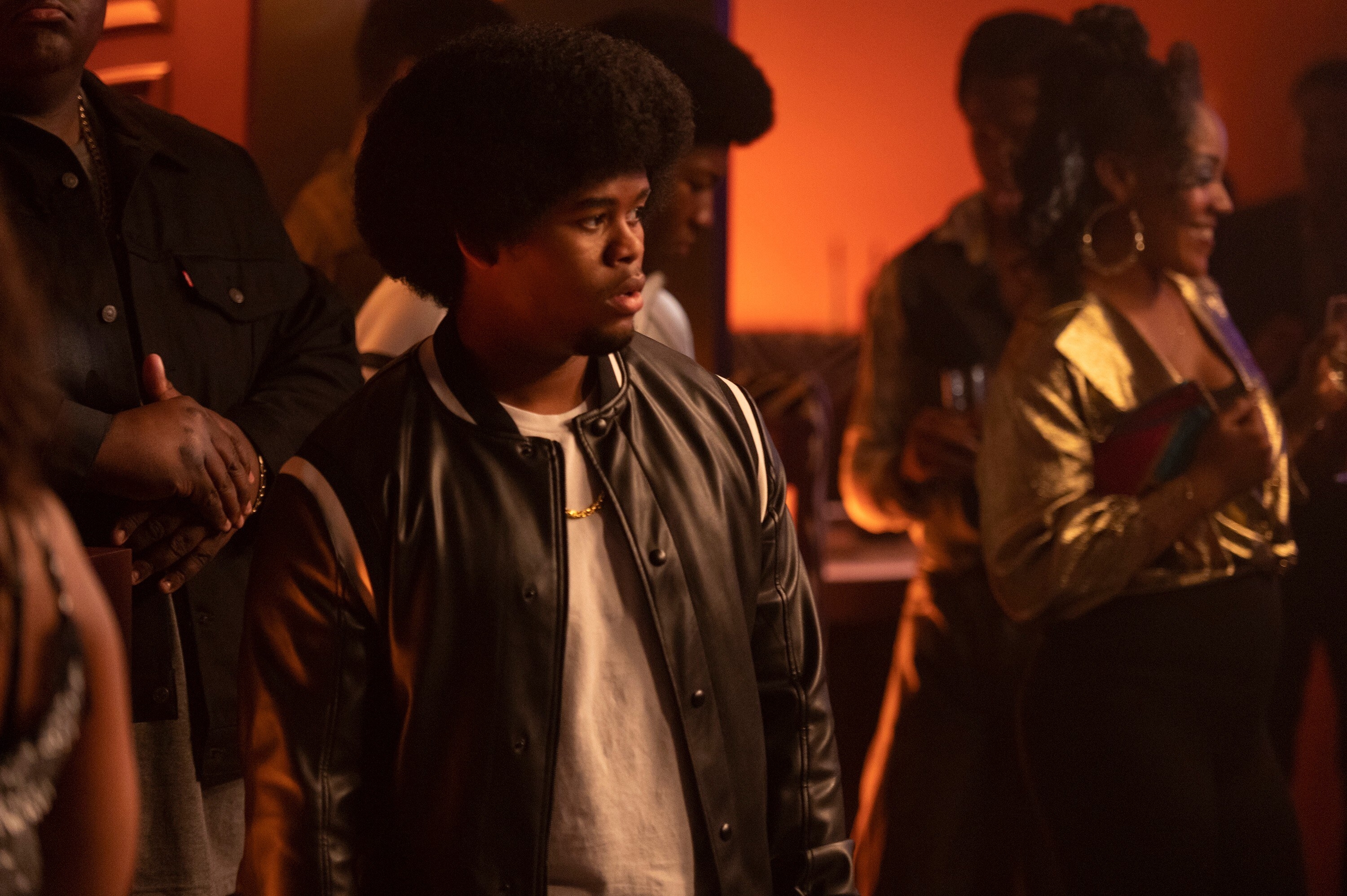 Isaiah John rocking a leather jacket and chain in a scene from Snowfall. 