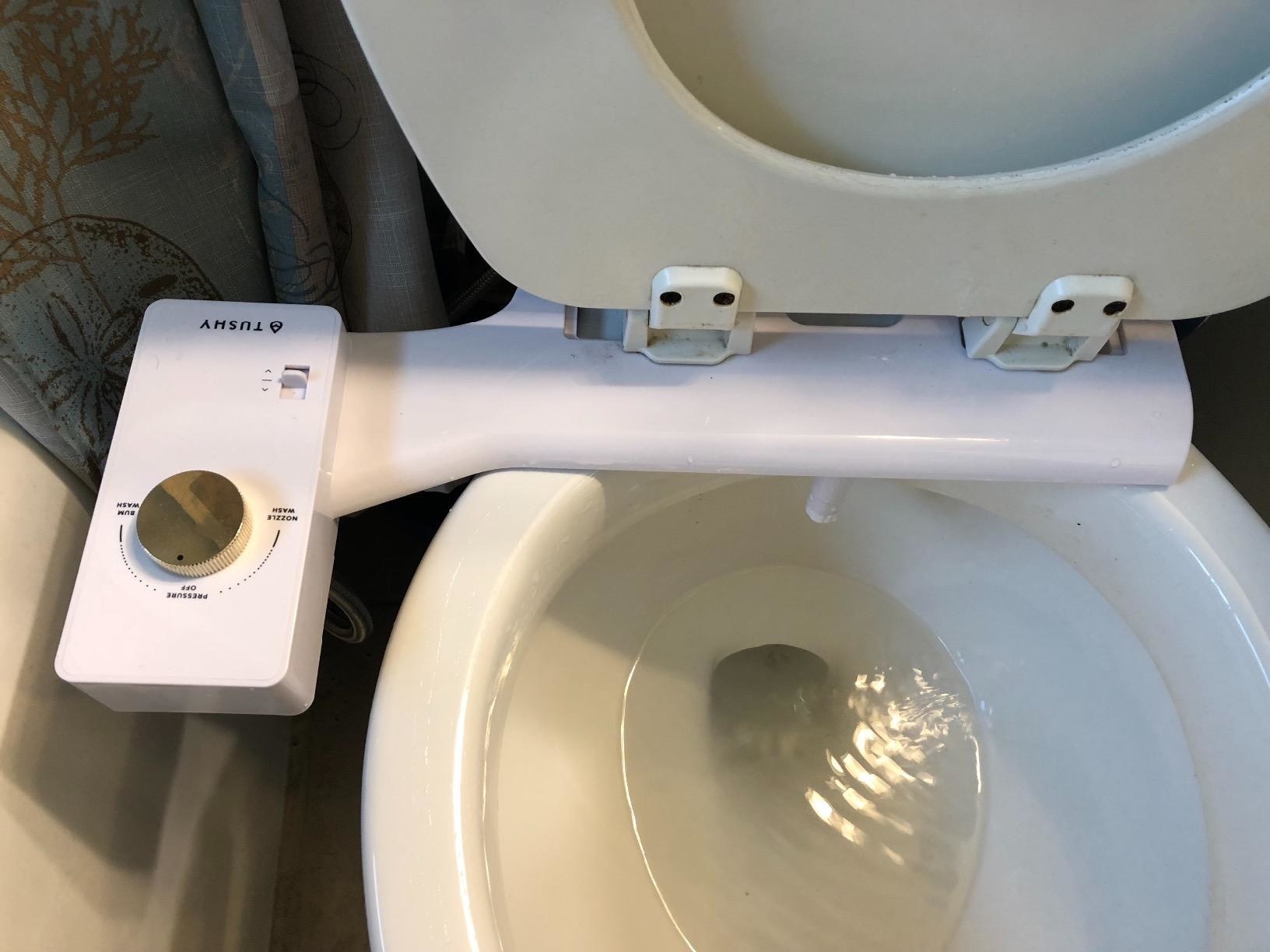 reviewer photo showing their Tushy bidet attached to their toilet 