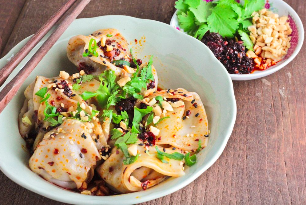 Two bowls of homemade dumplings drizzled with chili oil