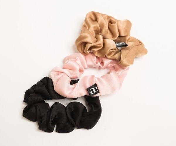 A tan, pink, and black silk scrunchie