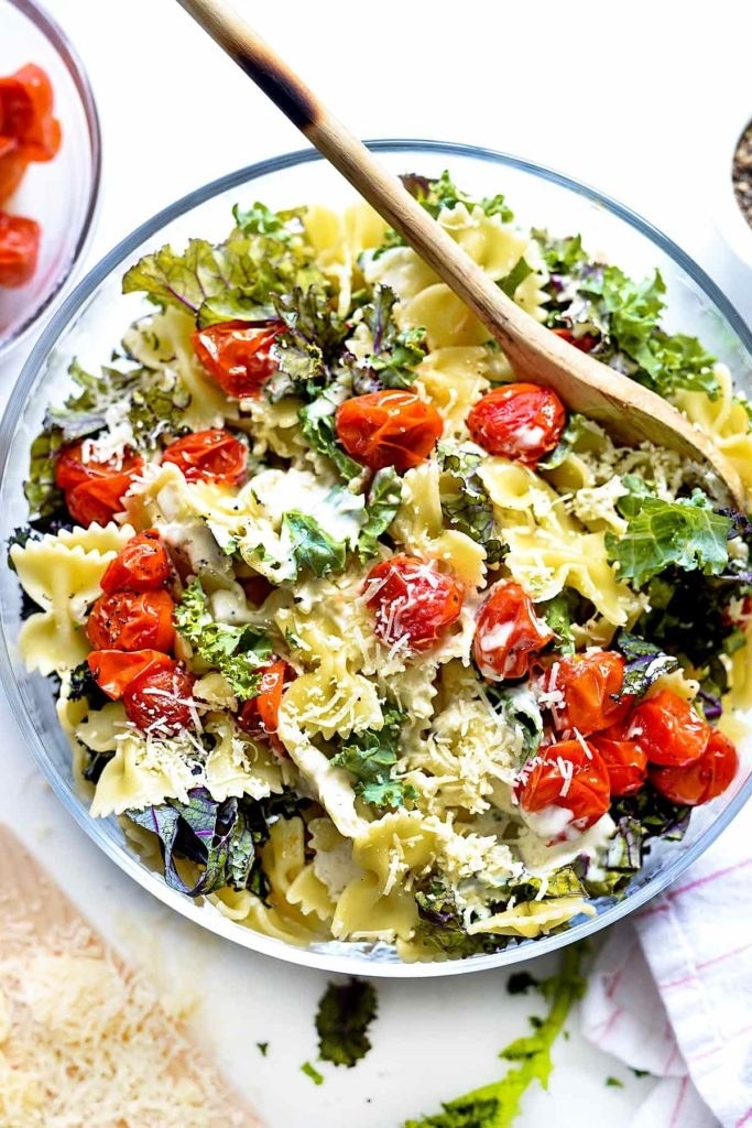 Pasta salad with tomatoes, kale, Parmesan, and dressing.