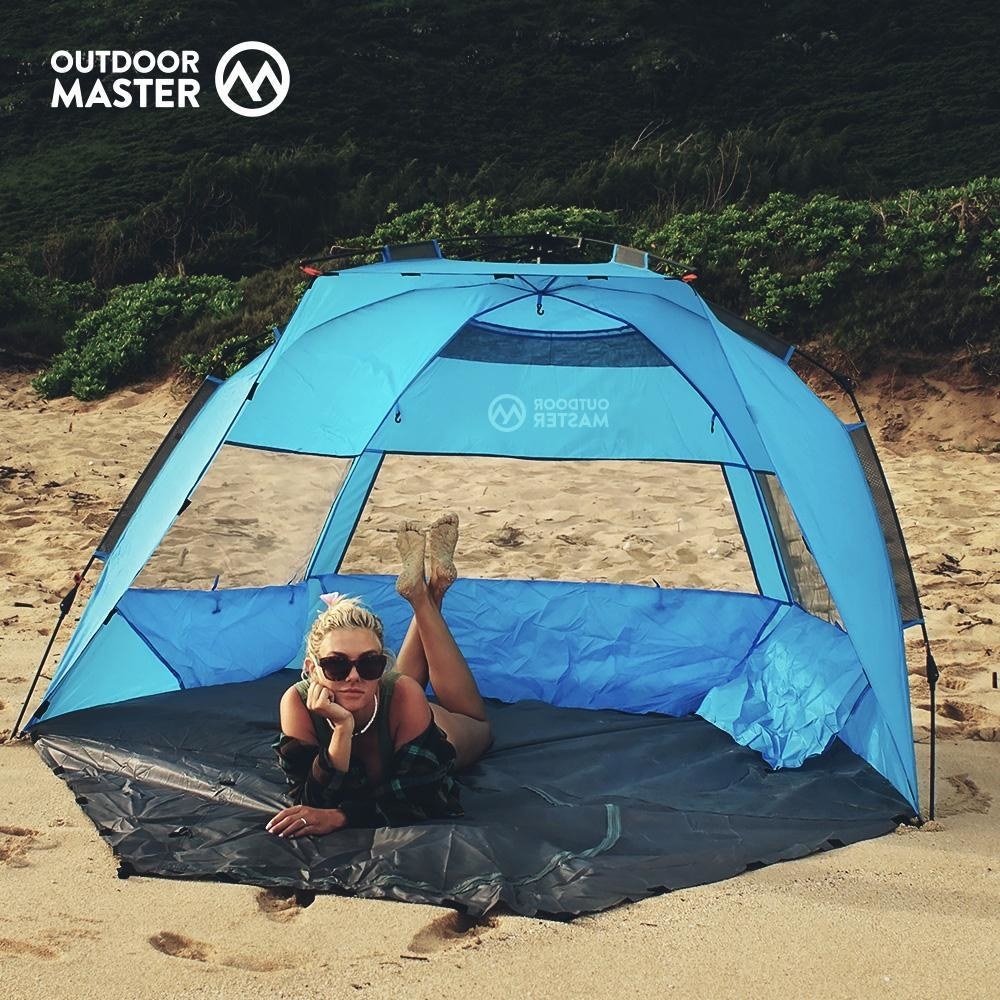 a person on the beach inside the pop up beach tent