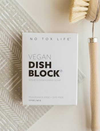 the vegan dish block packaging next to a scrub brush