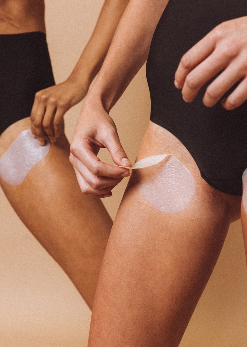 the long oval-shaped white sheet mask applied to the inner thigh of two models