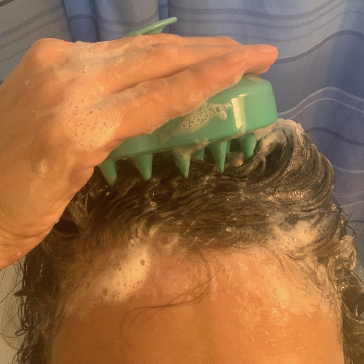person using the scalp shampoo brush
